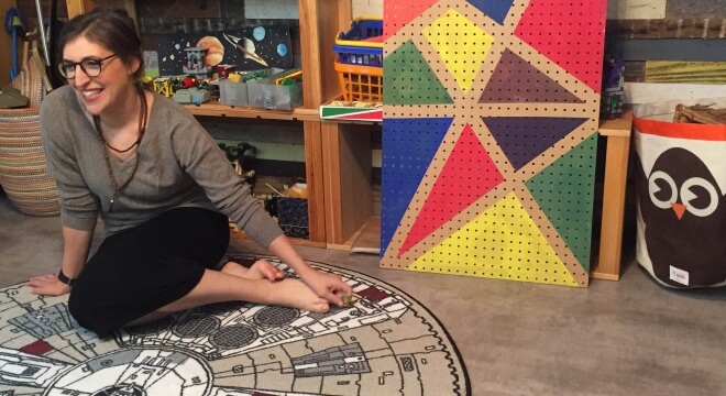During the video shoot, Mayim sits on the Millennium Falcon rug in her sons' room at home (photo: GrokNation.com)