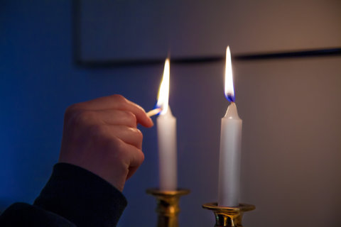 How many Shabbat candles does a divorced woman light?