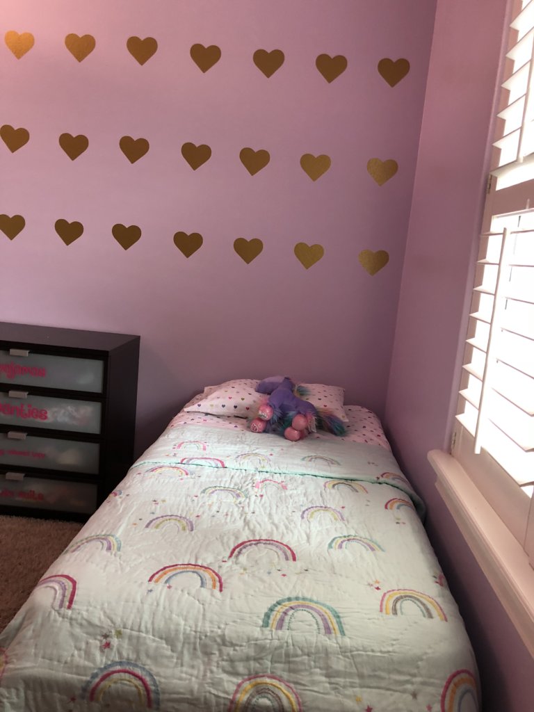 Rainbow bedding and hearts on the wall